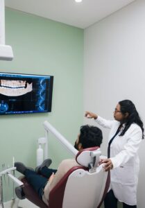 Dr. nayak with a patient looking at dental xrays